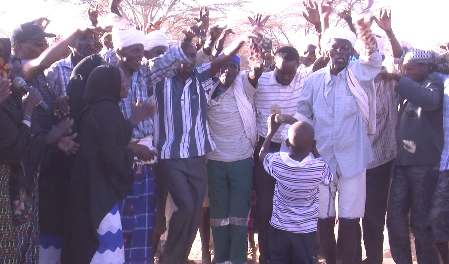 Community members raise their hands in celebration.